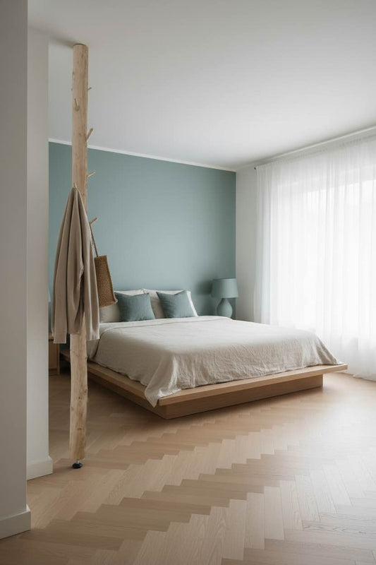 Garderobe mit Klamotten im Schlafzimmer mit Parkett. Klamotten sind auf einem Baumstamm aufgehängt.