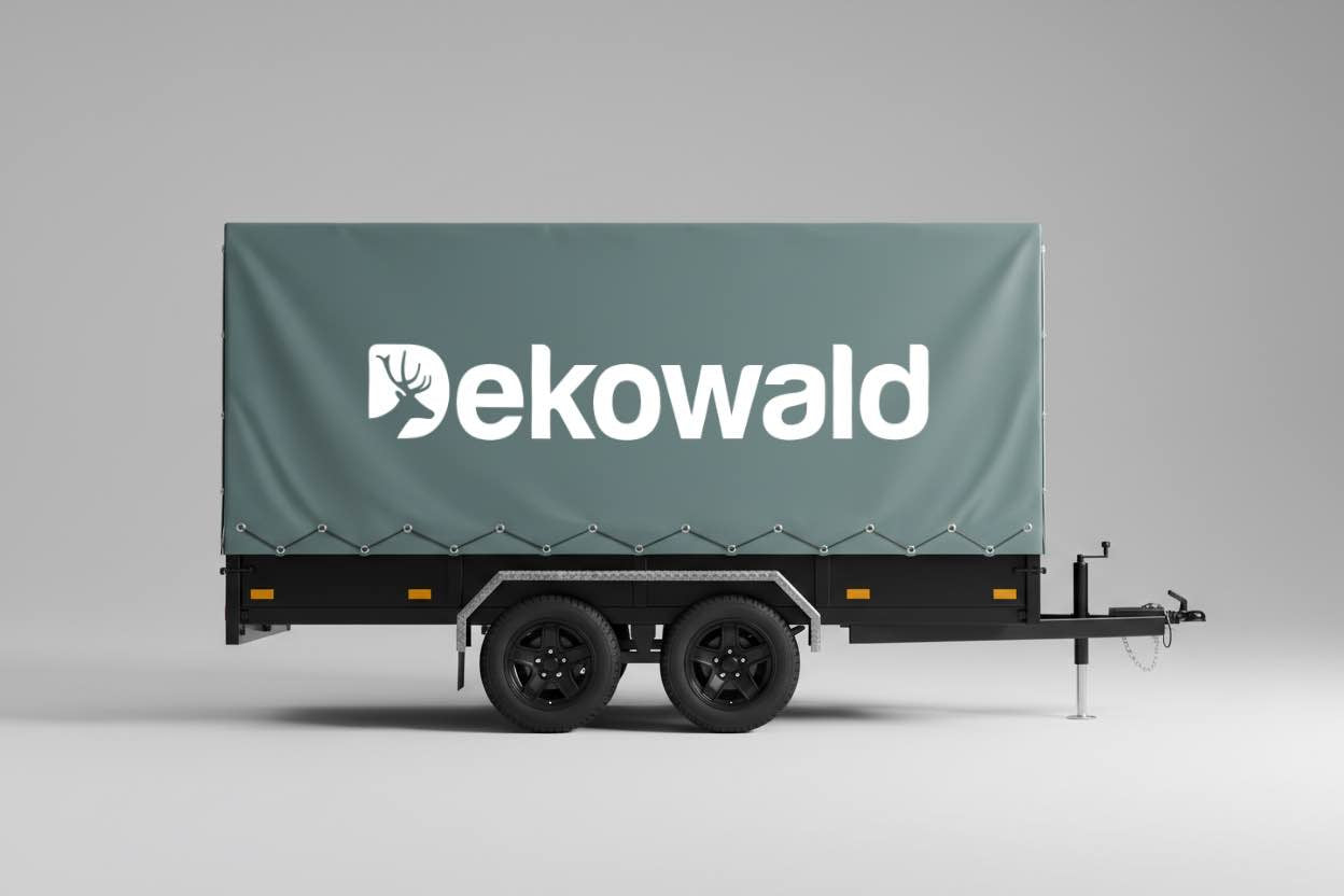 Anhänger mit grüner Plane und Logo von Dekowald. Abholung vor Ort möglich.